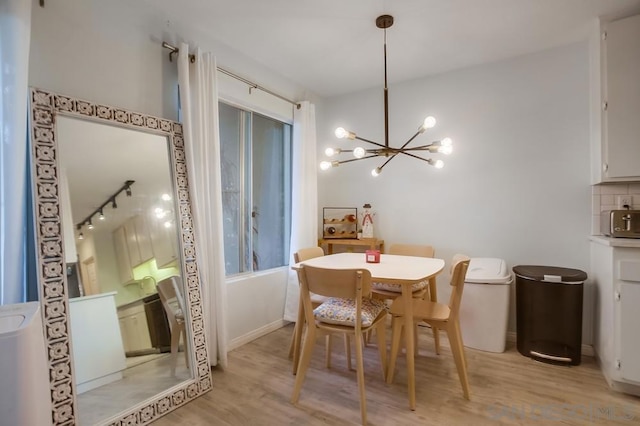 dining space with a notable chandelier and light hardwood / wood-style flooring