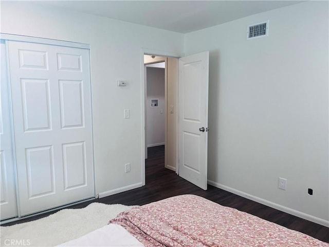 bedroom featuring dark wood-type flooring and a closet