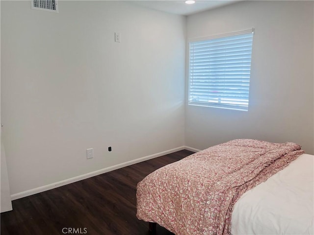 bedroom with dark hardwood / wood-style flooring