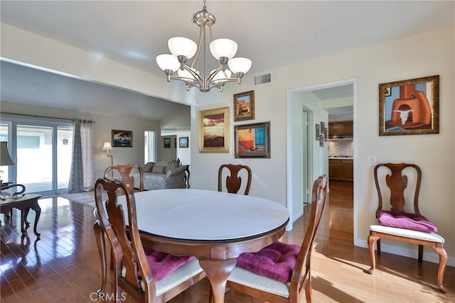 dining space featuring hardwood / wood-style flooring and a notable chandelier