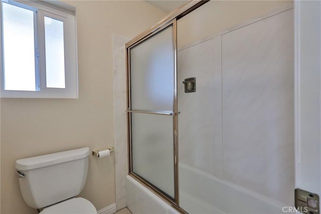 bathroom featuring shower / bath combination with glass door and toilet