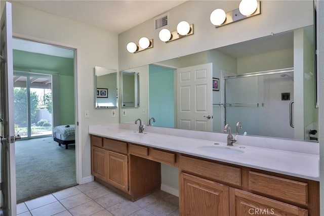 bathroom featuring vanity, tile patterned flooring, and a shower with door