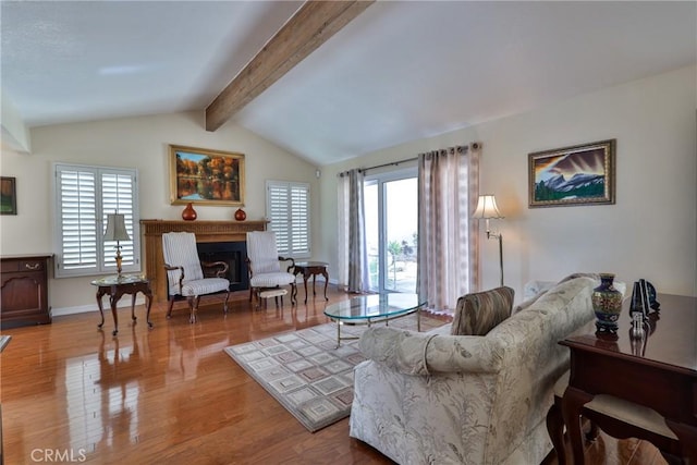 living room featuring lofted ceiling with beams, hardwood / wood-style floors, and a wealth of natural light