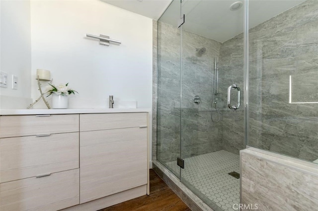 bathroom with vanity, a shower with shower door, and wood-type flooring