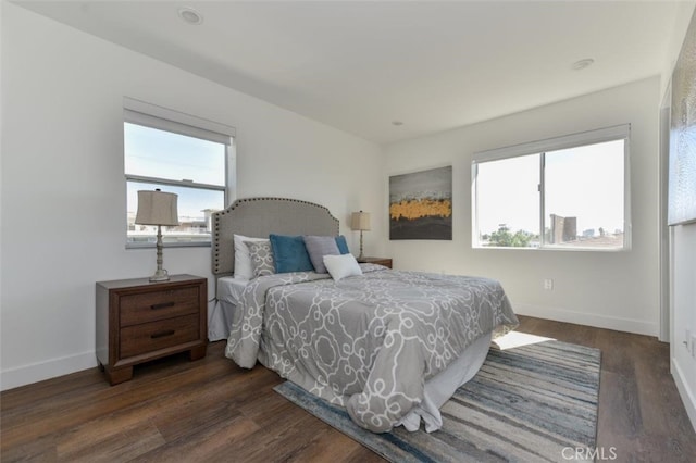 bedroom with dark hardwood / wood-style flooring and multiple windows