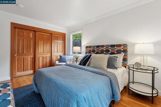 bedroom featuring crown molding, hardwood / wood-style flooring, and a closet