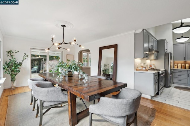 dining space featuring an inviting chandelier, crown molding, and light hardwood / wood-style floors