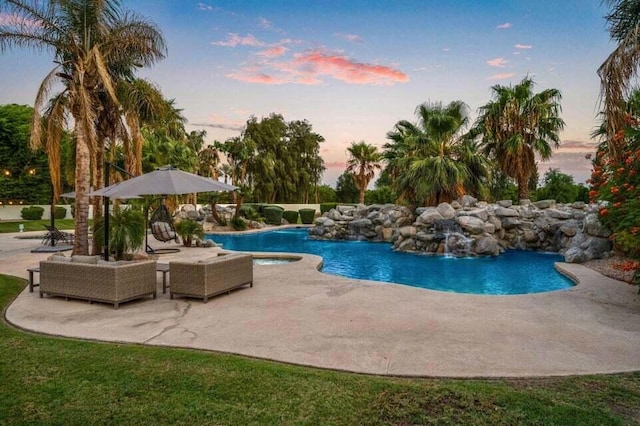 pool at dusk featuring a patio area