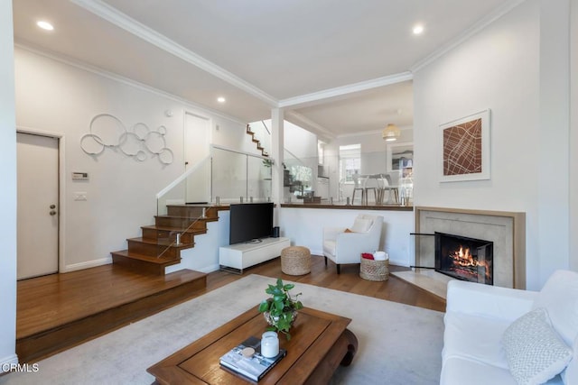 living room with crown molding, hardwood / wood-style floors, and a high end fireplace