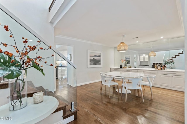 dining space featuring wood-type flooring and ornamental molding