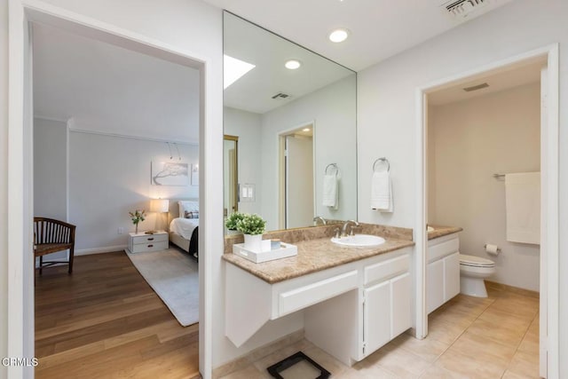 bathroom featuring vanity, wood-type flooring, and toilet