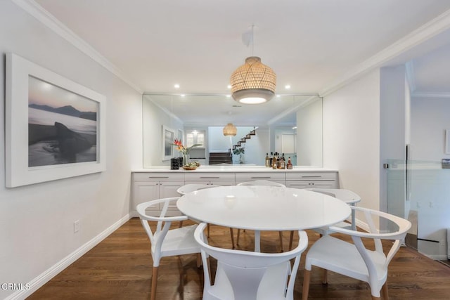 dining space with ornamental molding and dark hardwood / wood-style floors