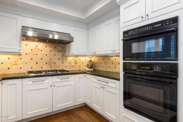 kitchen featuring dark wood-type flooring, white cabinetry, crown molding, dark stone counters, and exhaust hood