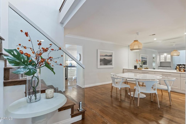 dining area with crown molding, a healthy amount of sunlight, and hardwood / wood-style floors