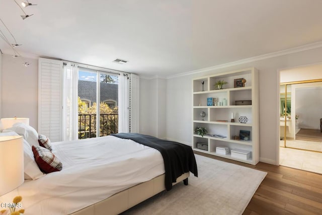 bedroom featuring wood-type flooring and crown molding