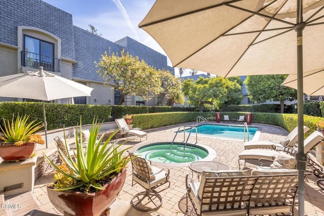 view of swimming pool featuring a community hot tub and a patio area