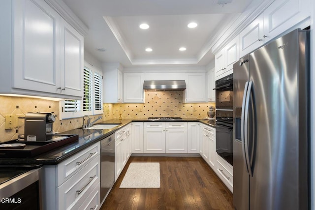 kitchen featuring appliances with stainless steel finishes, range hood, and white cabinets