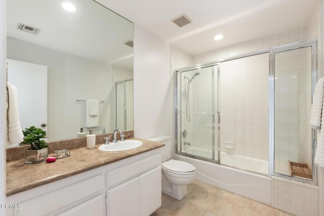 full bathroom with tile patterned flooring, vanity, shower / bath combination with glass door, and toilet