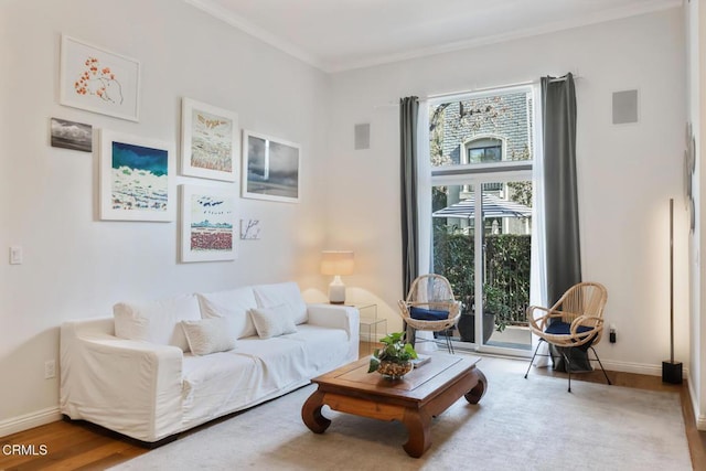 living area featuring hardwood / wood-style flooring and crown molding