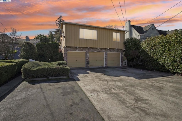 property exterior at dusk featuring a garage