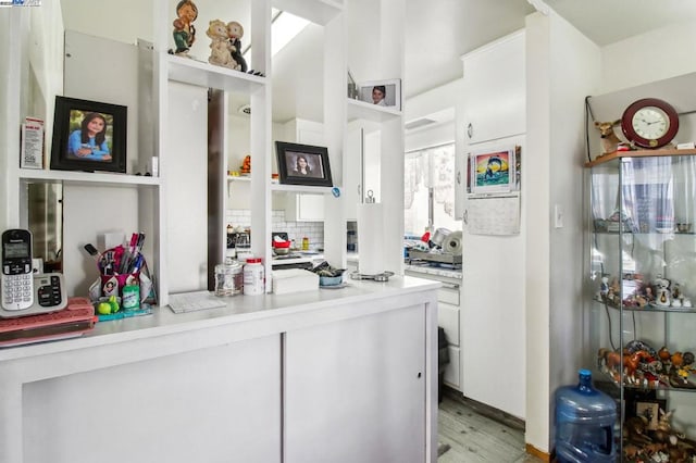 kitchen featuring white cabinets, light hardwood / wood-style floors, and decorative backsplash