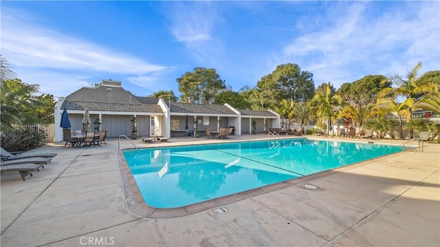 pool with a patio area and fence