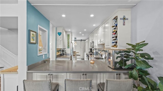interior space with recessed lighting, stainless steel microwave, and a sink