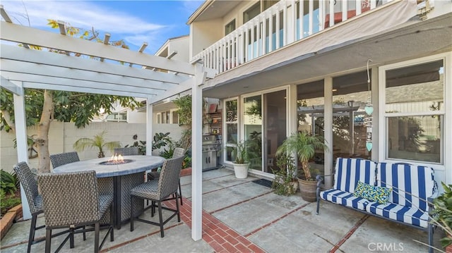 view of patio / terrace featuring a pergola, a fire pit, and a balcony