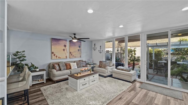 living room with ceiling fan, a wall of windows, and dark hardwood / wood-style flooring