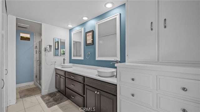 bathroom featuring a sink, a shower stall, recessed lighting, and double vanity
