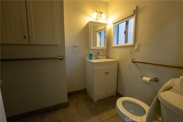 bathroom with tile patterned flooring, vanity, and toilet