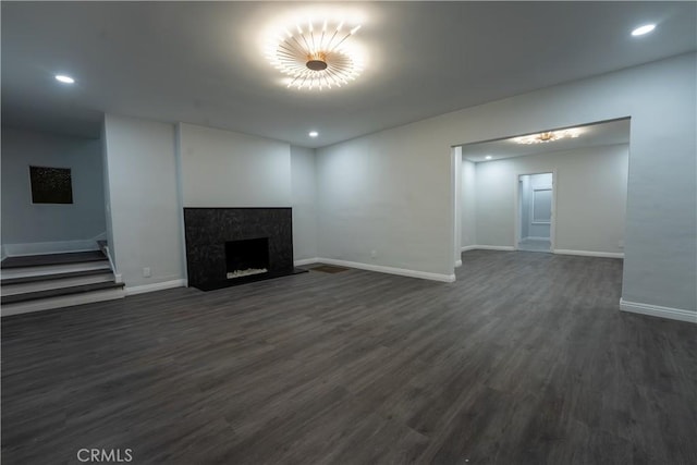 unfurnished living room with dark wood-style floors, a fireplace, baseboards, and recessed lighting