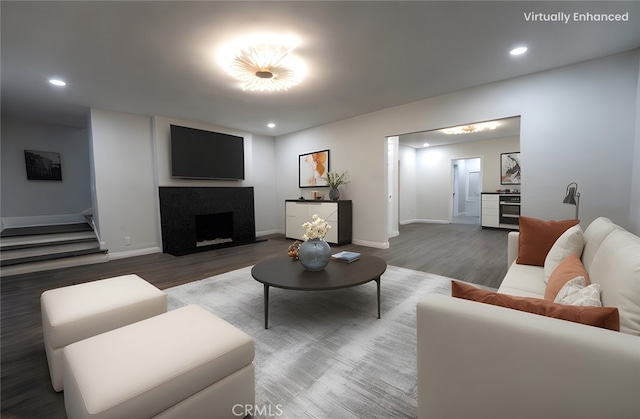 living area featuring recessed lighting, stairway, wood finished floors, and a fireplace