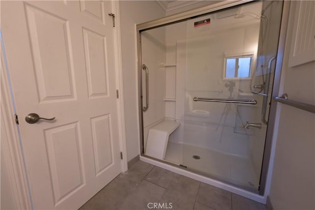 bathroom with a stall shower and tile patterned flooring