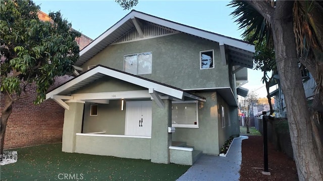 view of front of house with stucco siding and fence