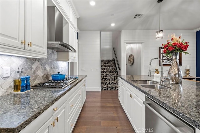 kitchen featuring wall chimney exhaust hood, sink, white cabinetry, dark stone counters, and stainless steel appliances