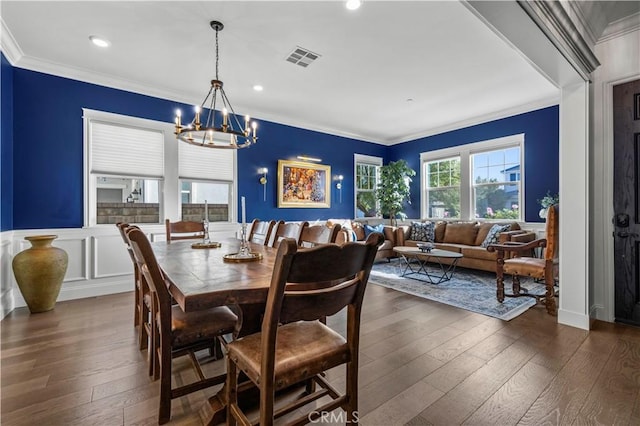 dining area featuring ornamental molding, dark hardwood / wood-style floors, and a notable chandelier