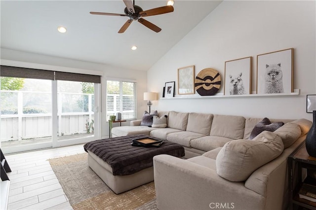 living room with hardwood / wood-style flooring, high vaulted ceiling, and ceiling fan