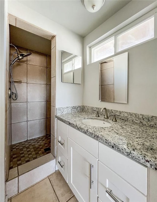 bathroom featuring tiled shower, vanity, and tile patterned floors