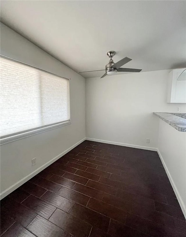 spare room featuring ceiling fan, dark hardwood / wood-style flooring, and vaulted ceiling