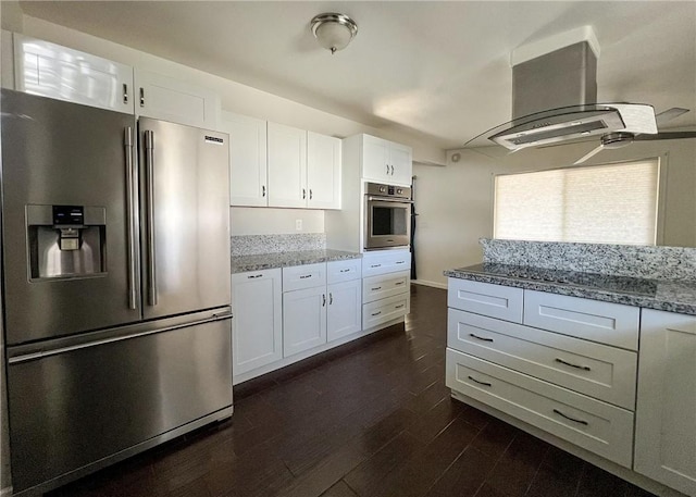 kitchen featuring light stone counters, island range hood, white cabinets, and appliances with stainless steel finishes