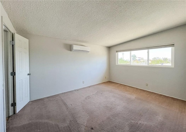 carpeted spare room featuring a textured ceiling and a wall mounted AC