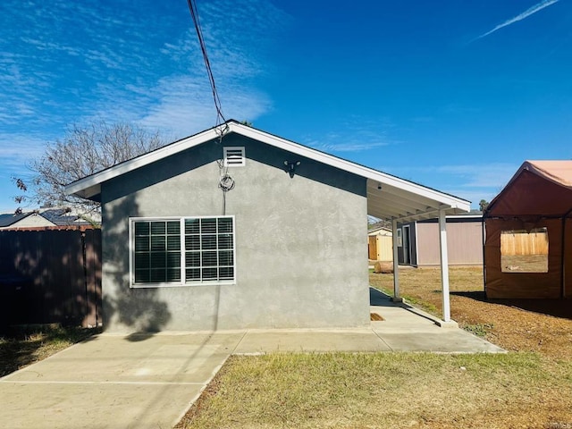 exterior space featuring a carport and a lawn