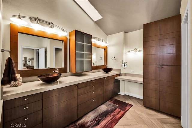 bathroom featuring vanity, parquet floors, and vaulted ceiling