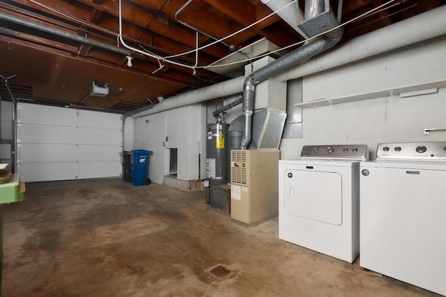 garage with a garage door opener, washer and dryer, and secured water heater