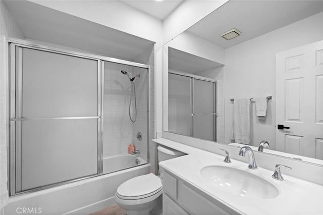 full bathroom with vanity, bath / shower combo with glass door, and toilet