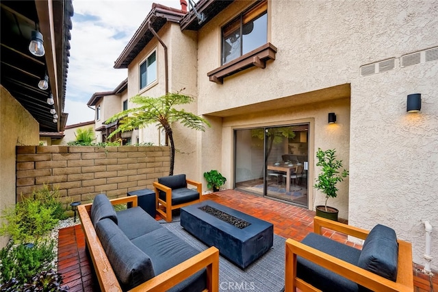 view of patio with an outdoor living space with a fire pit