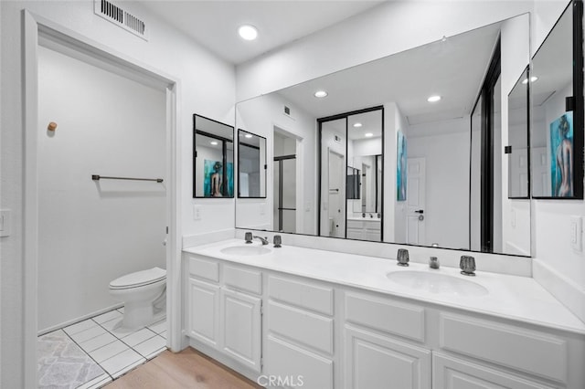 bathroom featuring vanity, wood-type flooring, and toilet