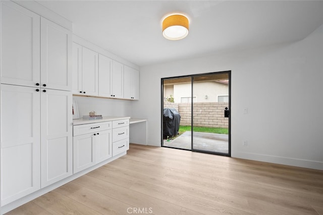 interior space with light hardwood / wood-style floors and white cabinets