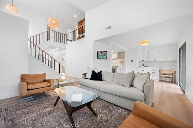 living room with a high ceiling and light wood-type flooring